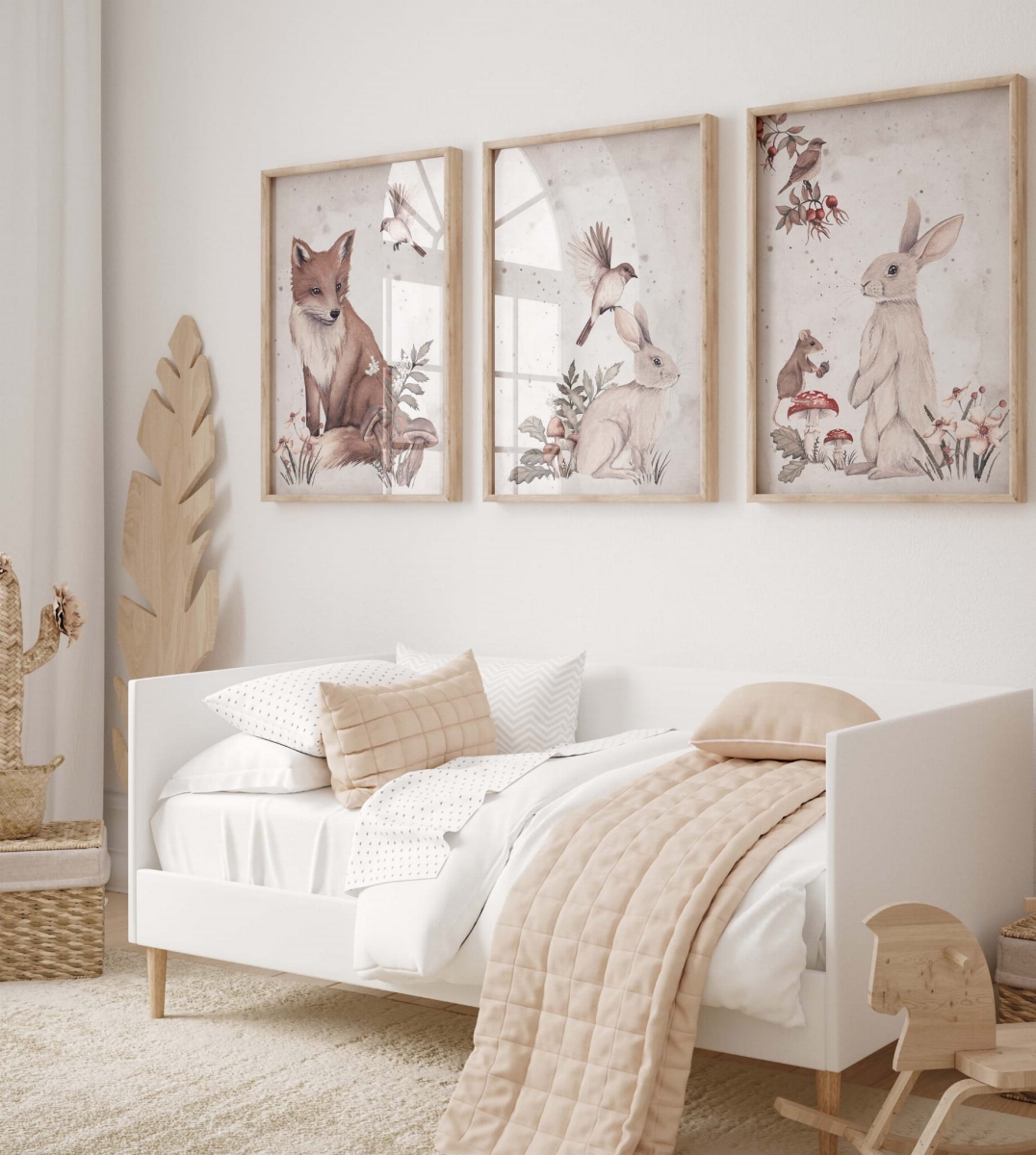 Trzy plakaty z leśnymi zwierzętami nad łóżkiem dziecięcym – dekoracja w stylu woodland